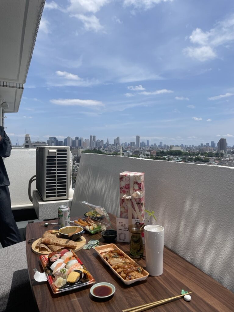 中庭コートハウスを間取りに選んだ理由 ルーツ　原点回帰 築54年賃貸マンションリビングから繋がるベランダ 青空の下引越し祝いでもらったワインを飲む昼下がりのランチ風景